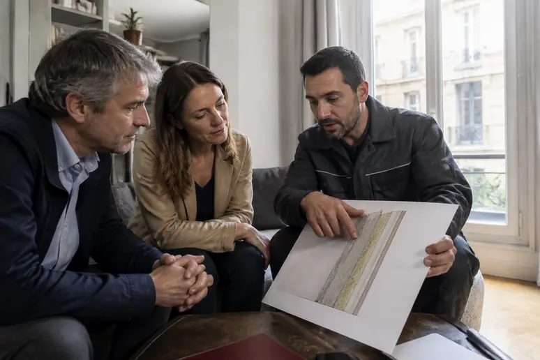 Couple de Lyon discutant de solutions d'isolation phonique pour leur mur mitoyen avec un professionnel