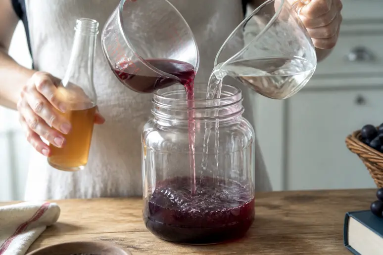 Mélange d'un tiers de vin, d'eau et de vinaigre non pasteurisé dans un bocal en verre