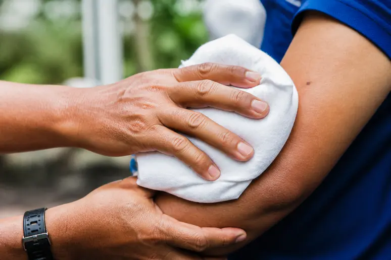Application d'une compresse froide enveloppée dans un tissu pour soulager la piqûre de taon.