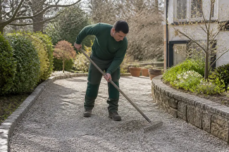 Allée gravillonnée d'un jardin nécessitant un entretien régulier des extérieurs