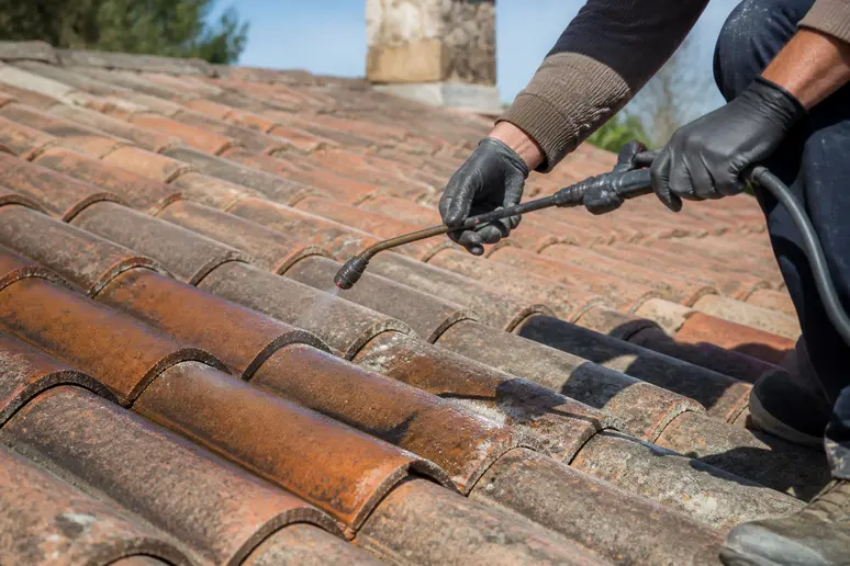 Application d'un hydrofuge coloré sur des tuiles de toiture par un artisan couvreur