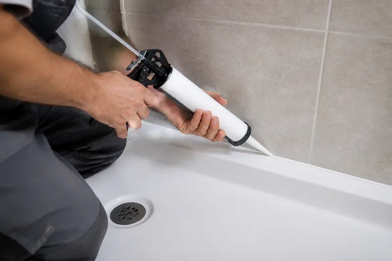 Application d'un joint en mastic élastomère périphérique sur un receveur de douche